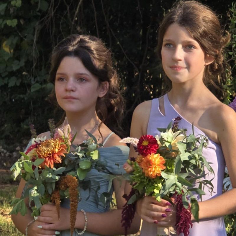 Two young girls holding bouquets of flowers in their hands