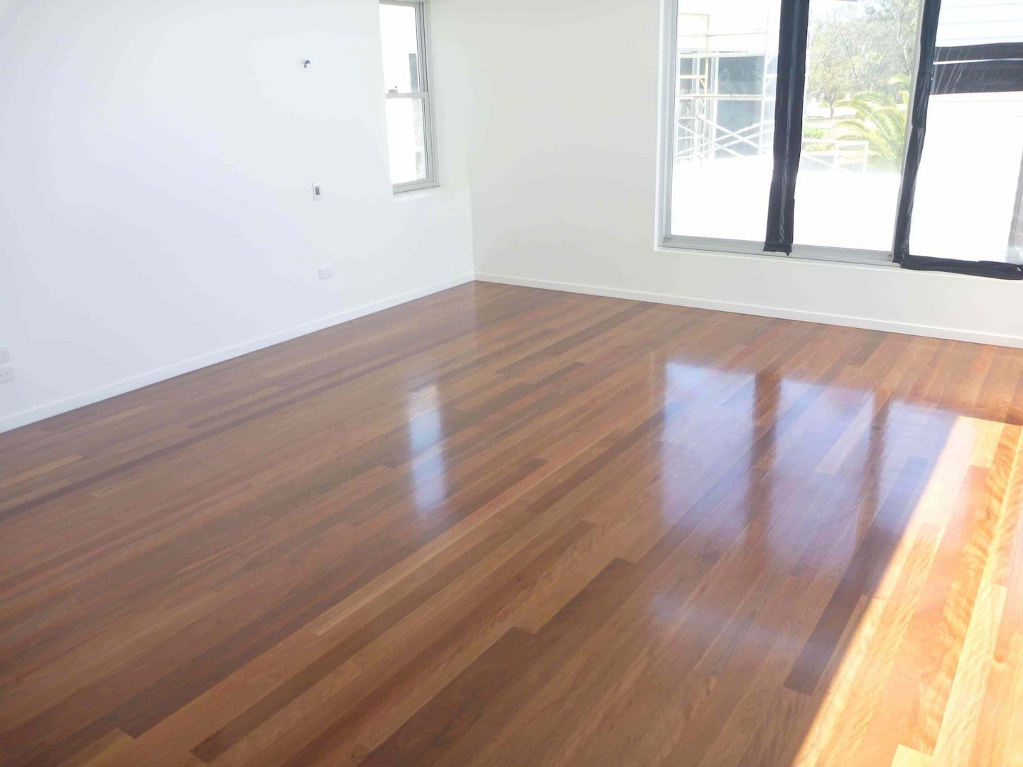Polished timber flooring and a sliding window — Flooring In Sharon, QLD