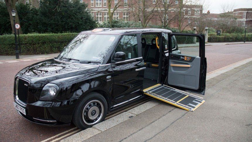 London electric taxi with wheelchair ramp extended for disabled passengers. 