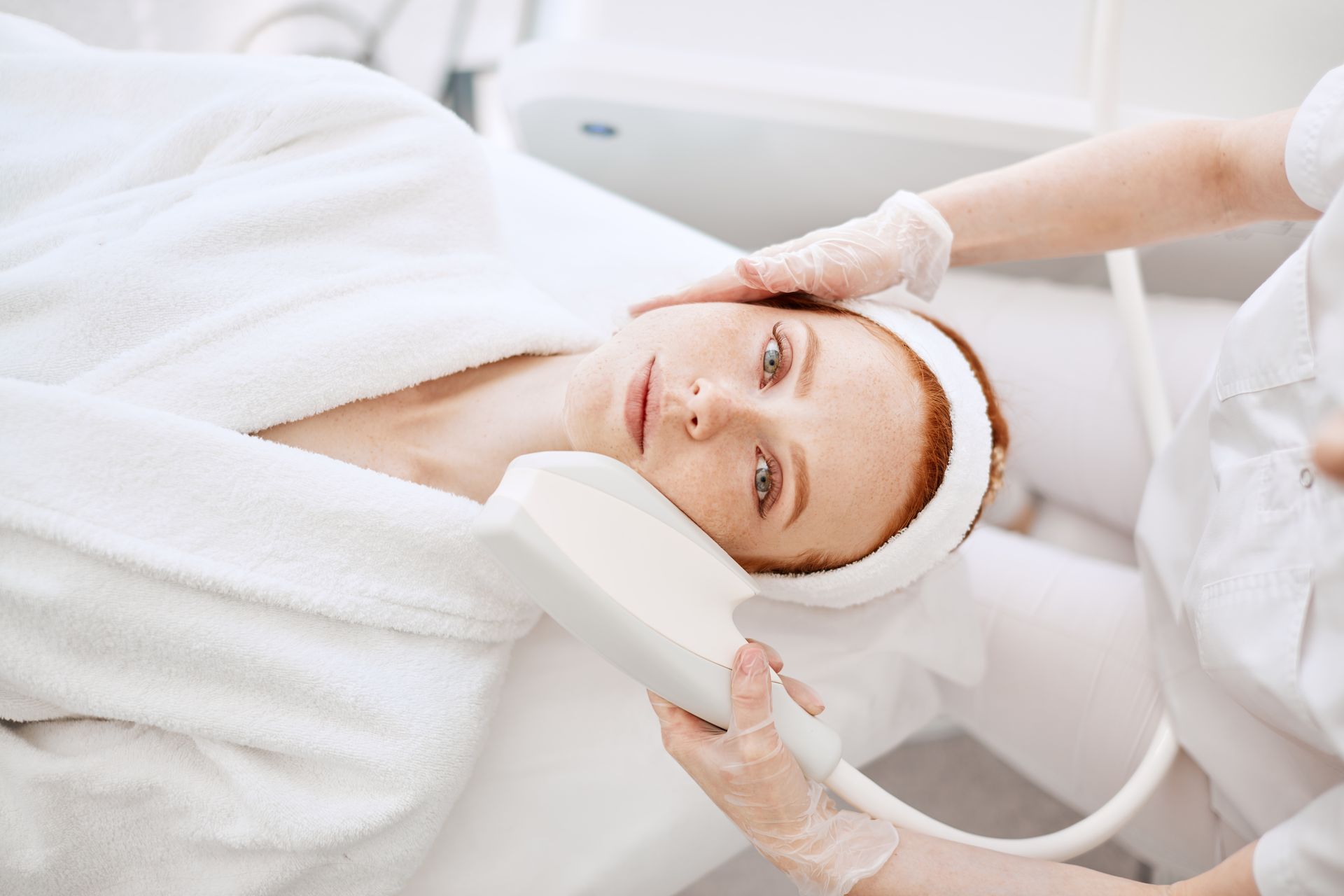 A woman is getting a laser treatment on her face.