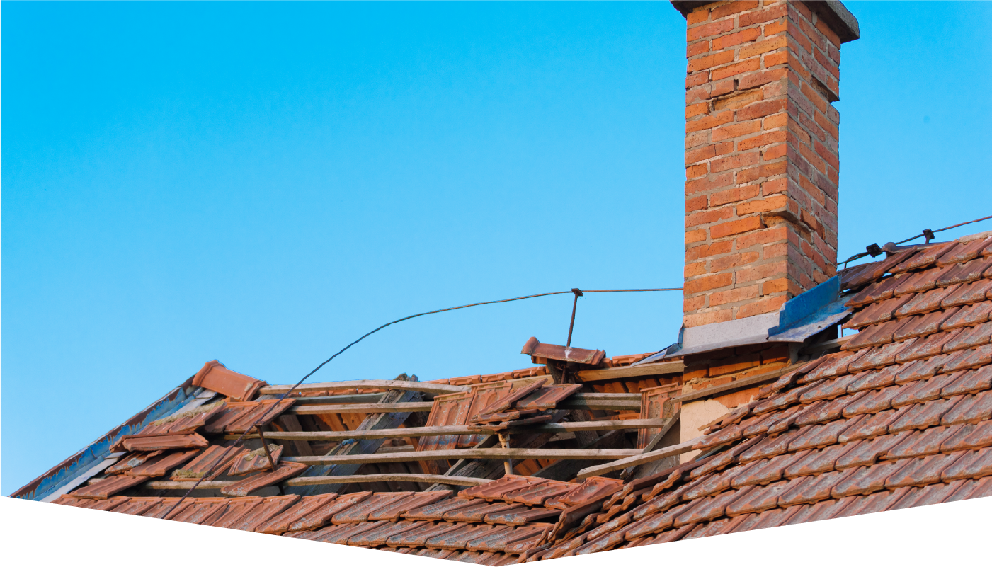A brick chimney on top of a roof with a blue sky in the background.