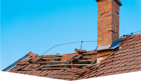 A brick chimney on top of a roof with a blue sky in the background.