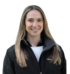 A woman wearing a nasa jacket smiles for the camera