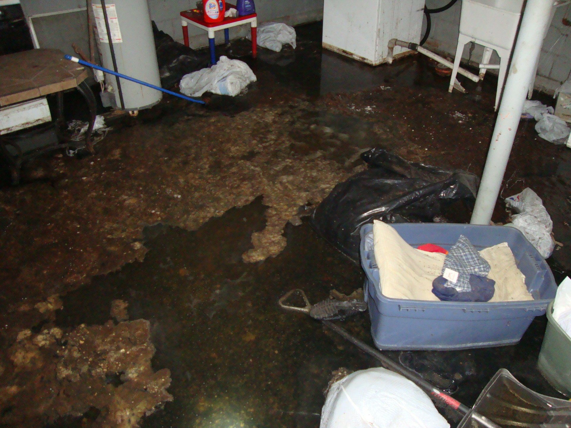 A dirty room with a blue box of sand on the floor