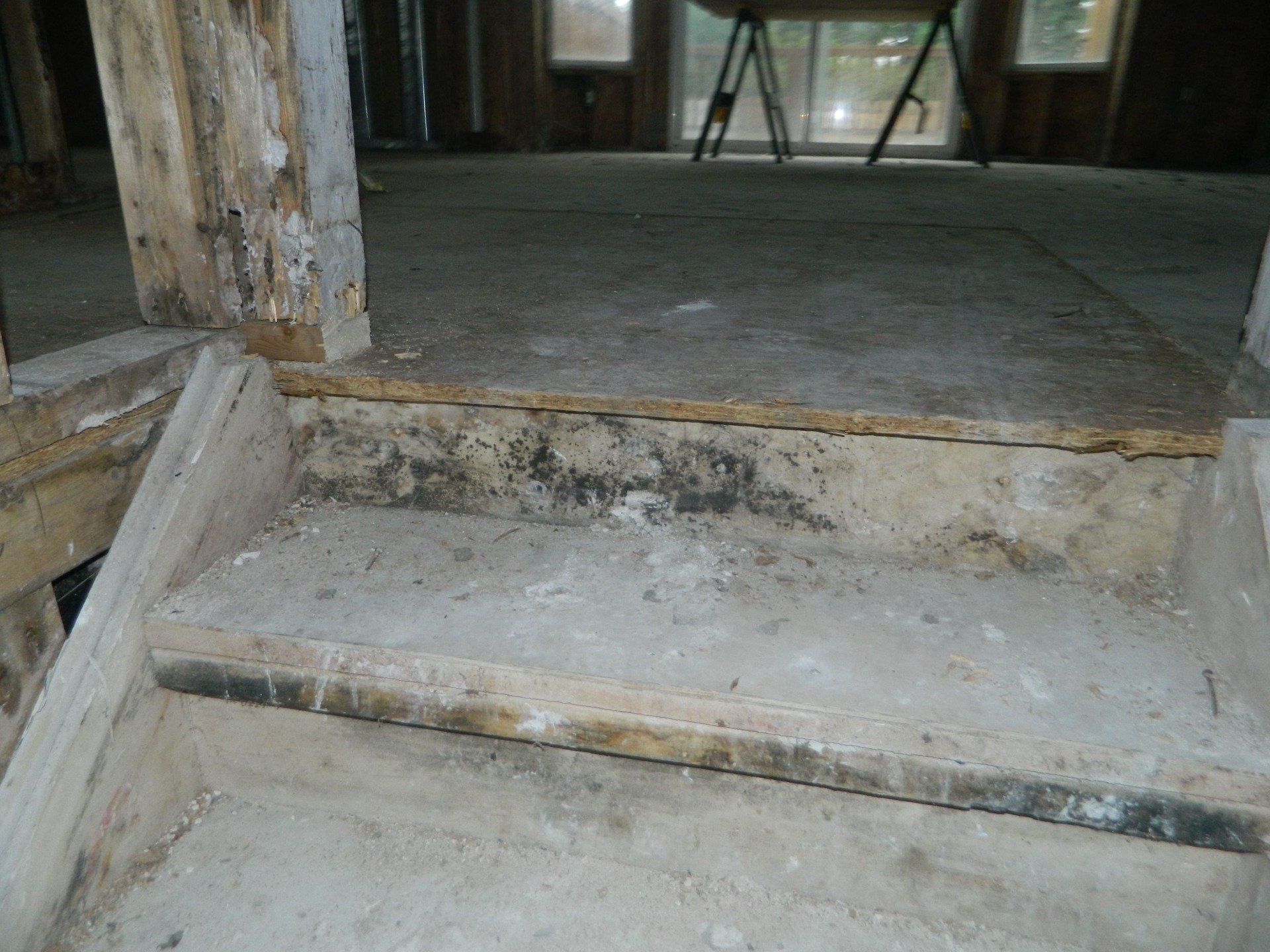 A wooden staircase in a room with a concrete floor
