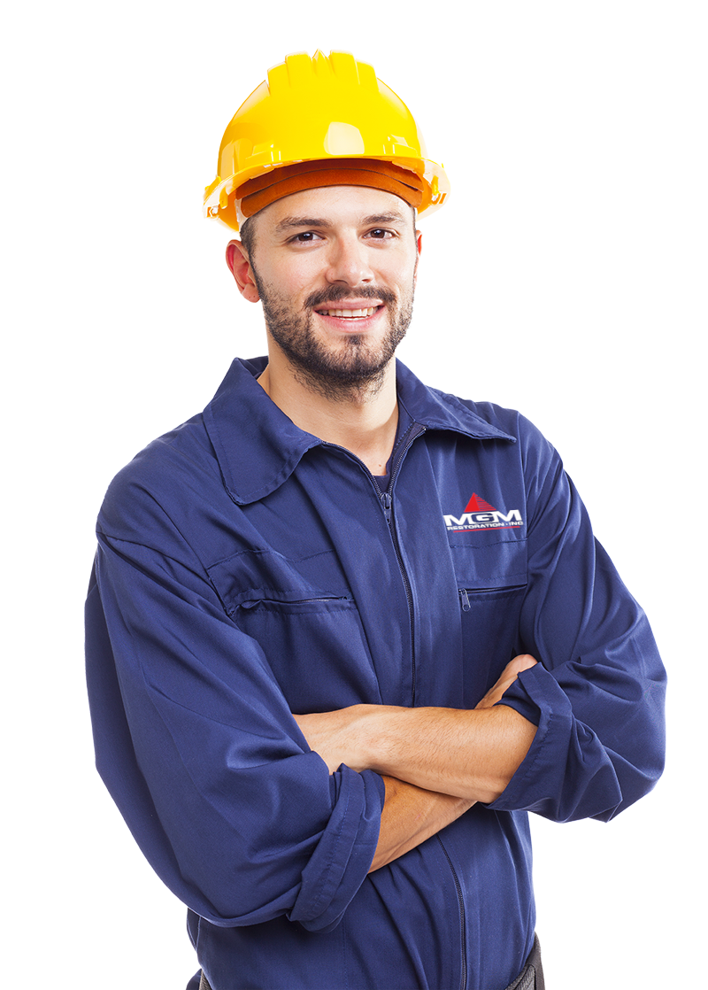 A man wearing a hard hat and overalls with his arms crossed