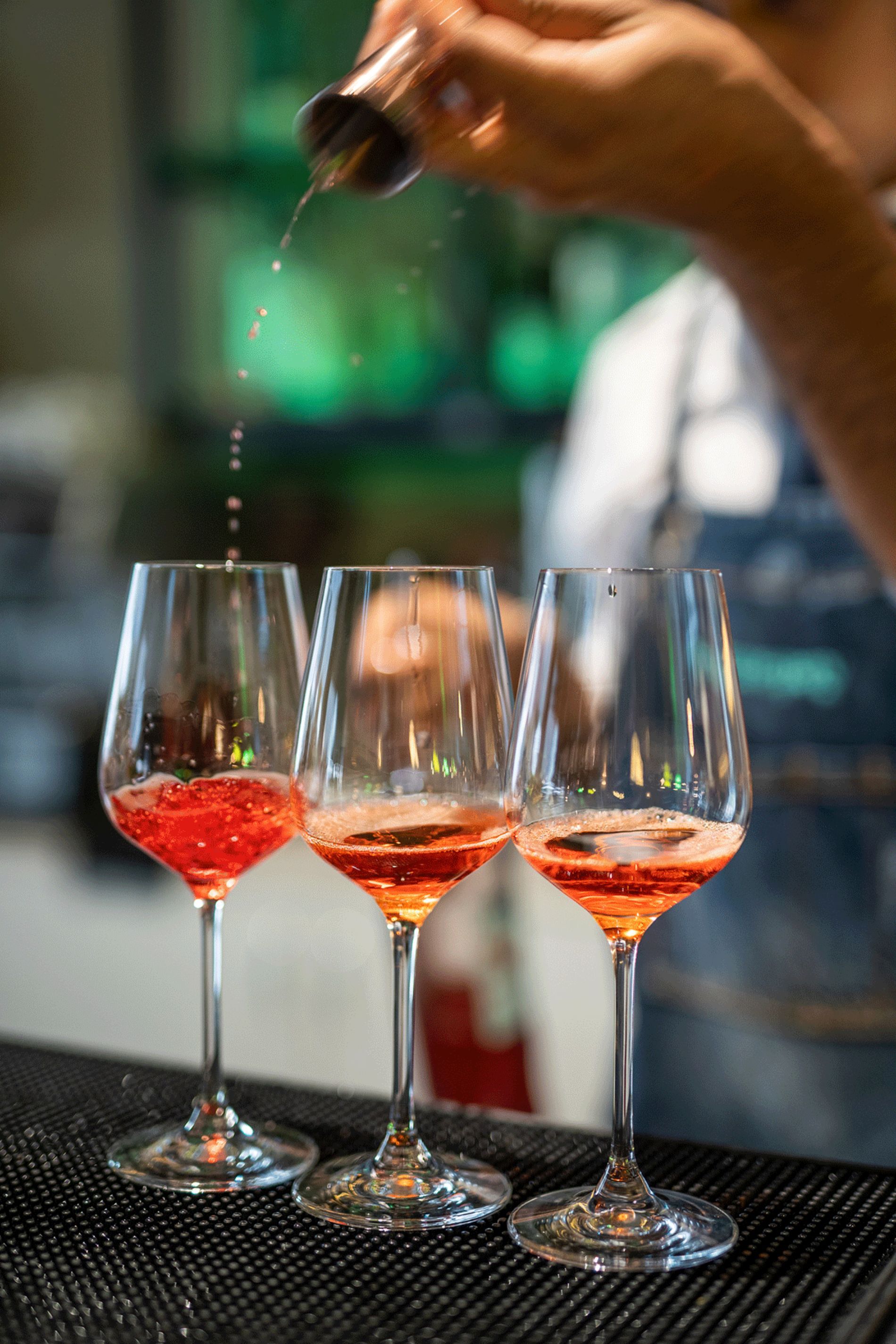 barman che prepara tre cocktail