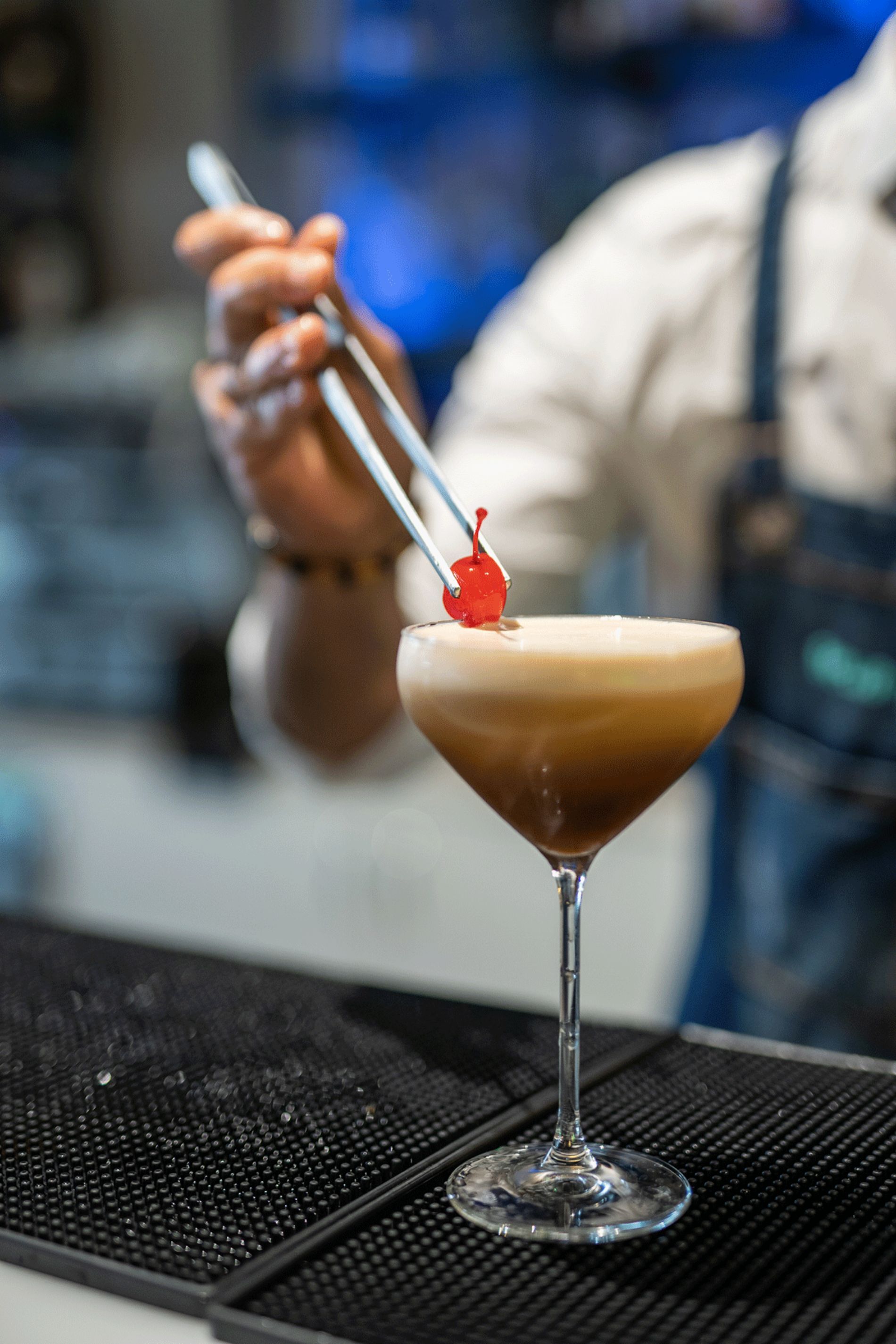 barman che posa ciliegina su cocktail al caffè