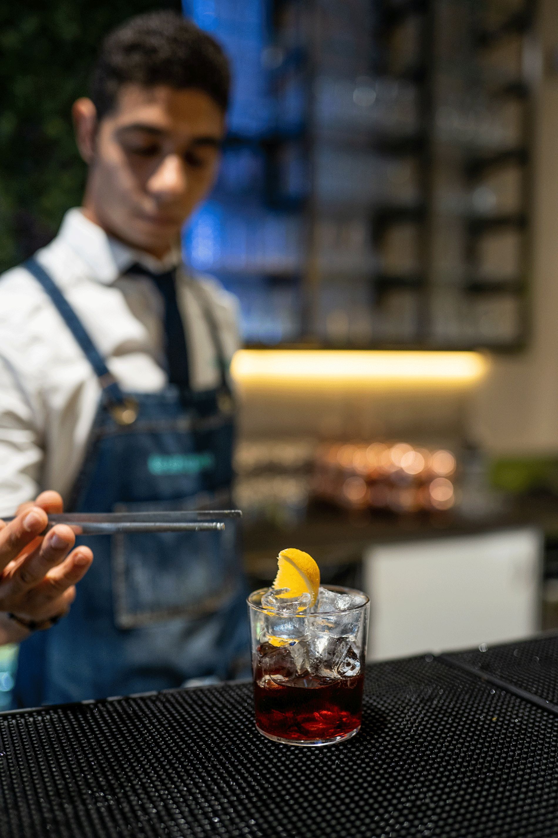 barman che serve cocktail con fettina di limone