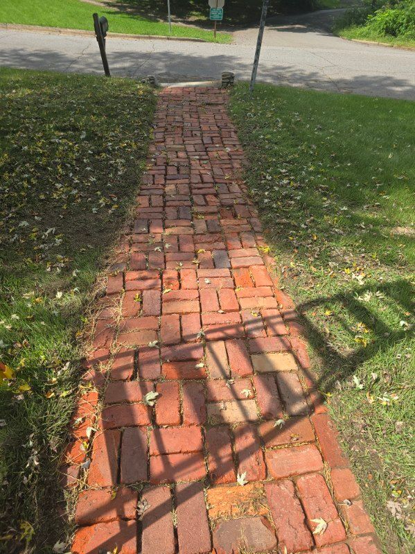 Brick walkway leading from the street through grass.