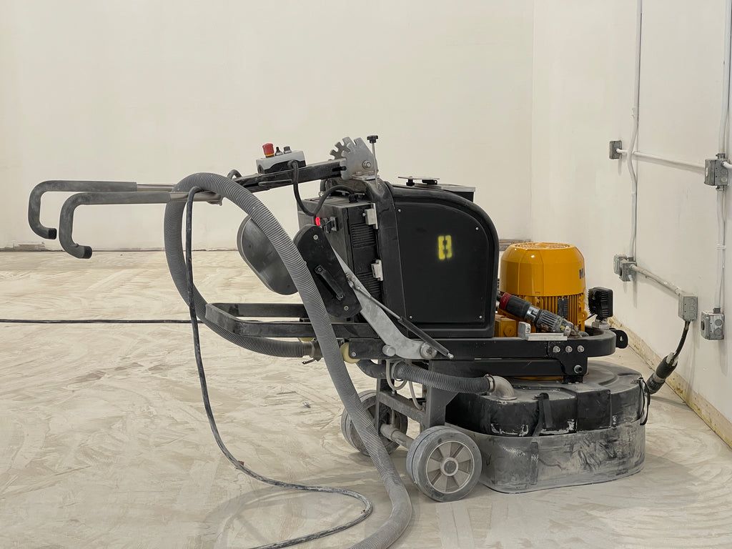 Industrial-grade concrete grinder on a freshly-ground concrete substrate.
