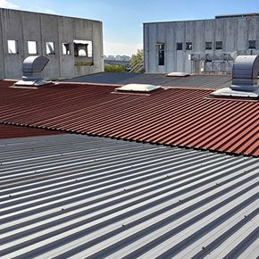 the roof of a building with a red roof and a gray roof .