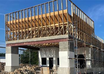 a building is being built with wooden beams and scaffolding .