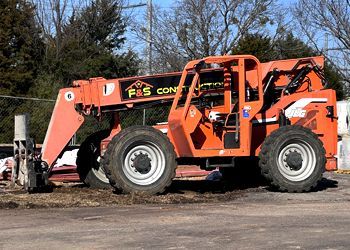 A large orange forklift is parked in a parking lot.