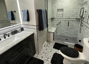 a bathroom with a toilet , sink , shower and mirror .