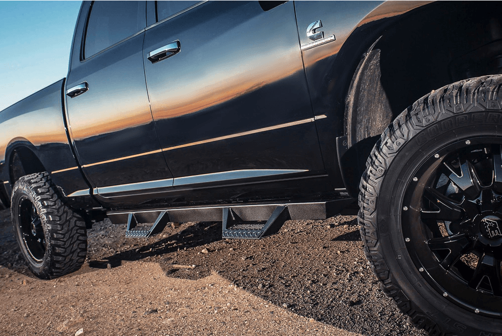 A black truck is parked on a dirt road.