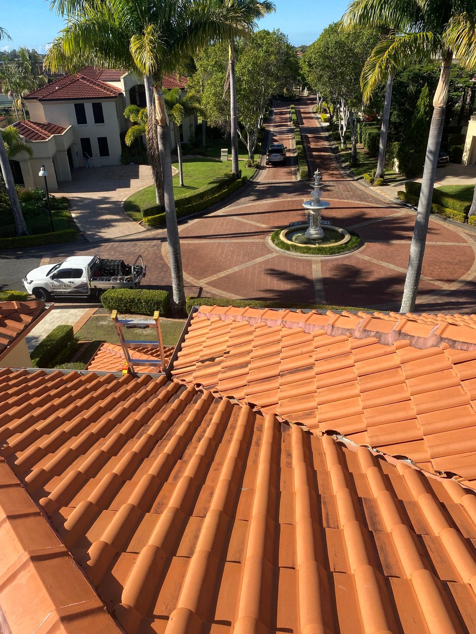Orange Tile Roof, Leading to a Brick Road With Fountain — Killiby & Co Roofing Pty Ltd in Northern Rivers, NSW