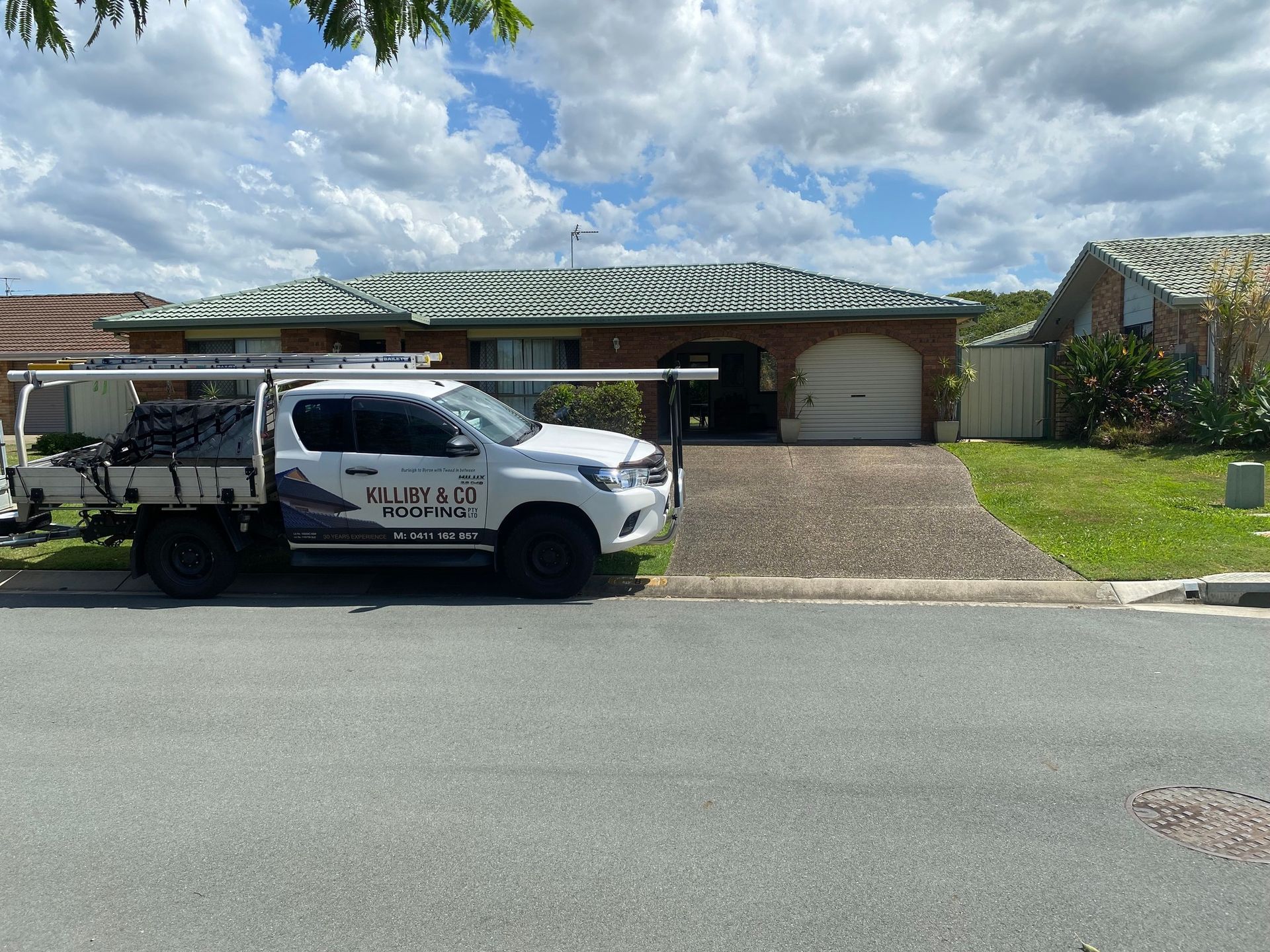 White Work Truck Parked in Front of a Brick House — Killiby & Co Roofing Pty Ltd in Coolangatta, NSW