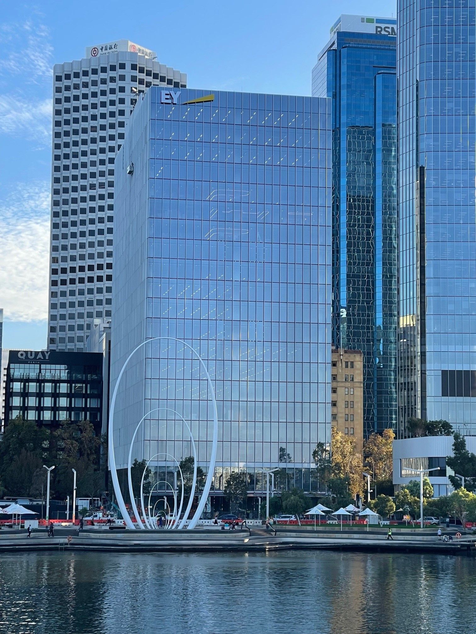 An artist 's impression of a large building with cars parked in front of it.