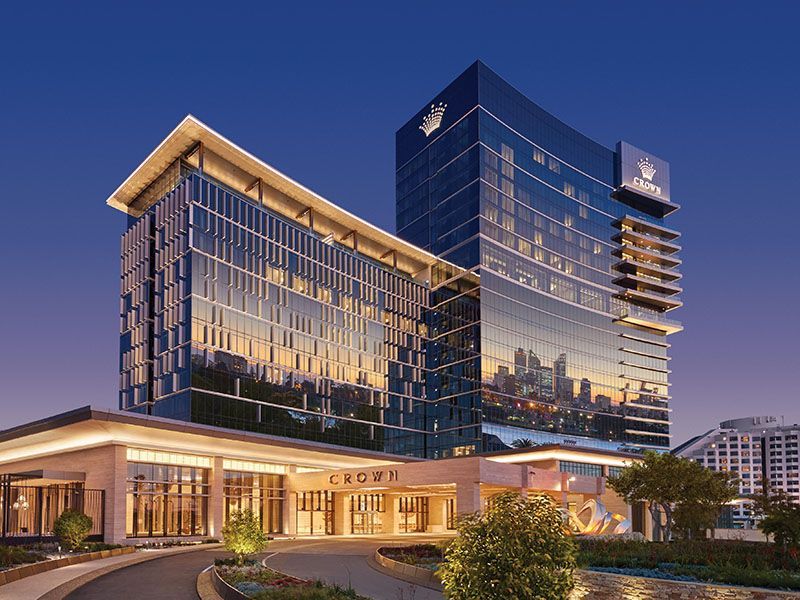 A group of people are walking in front of a tall building.