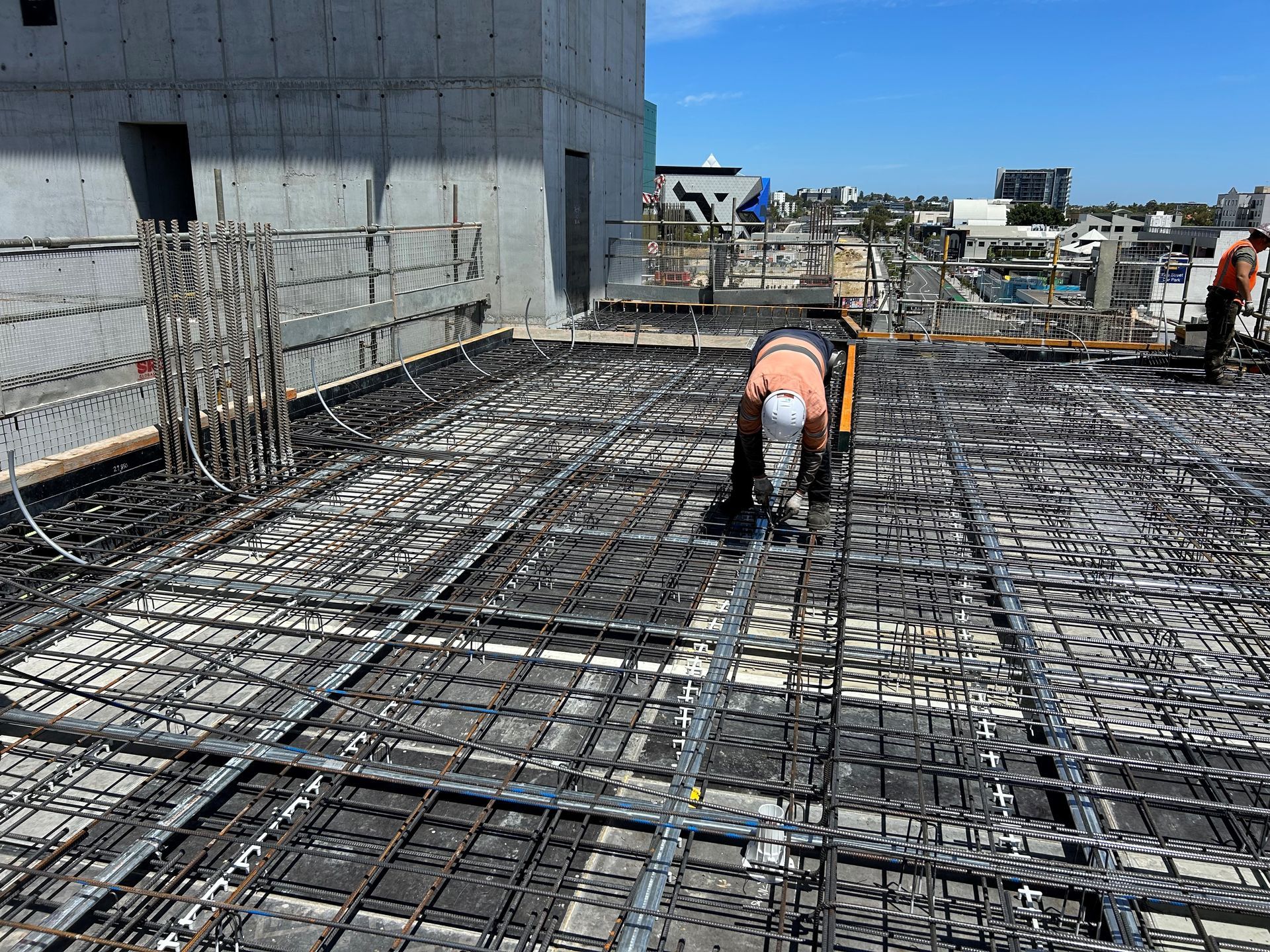 A construction worker is working on a concrete floor.