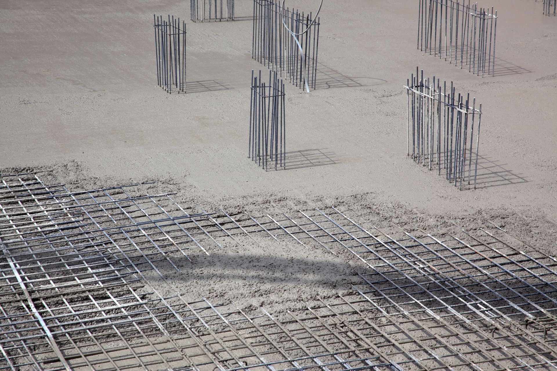 Steel building armature with cement, highlighting steel reinforcement techniques.