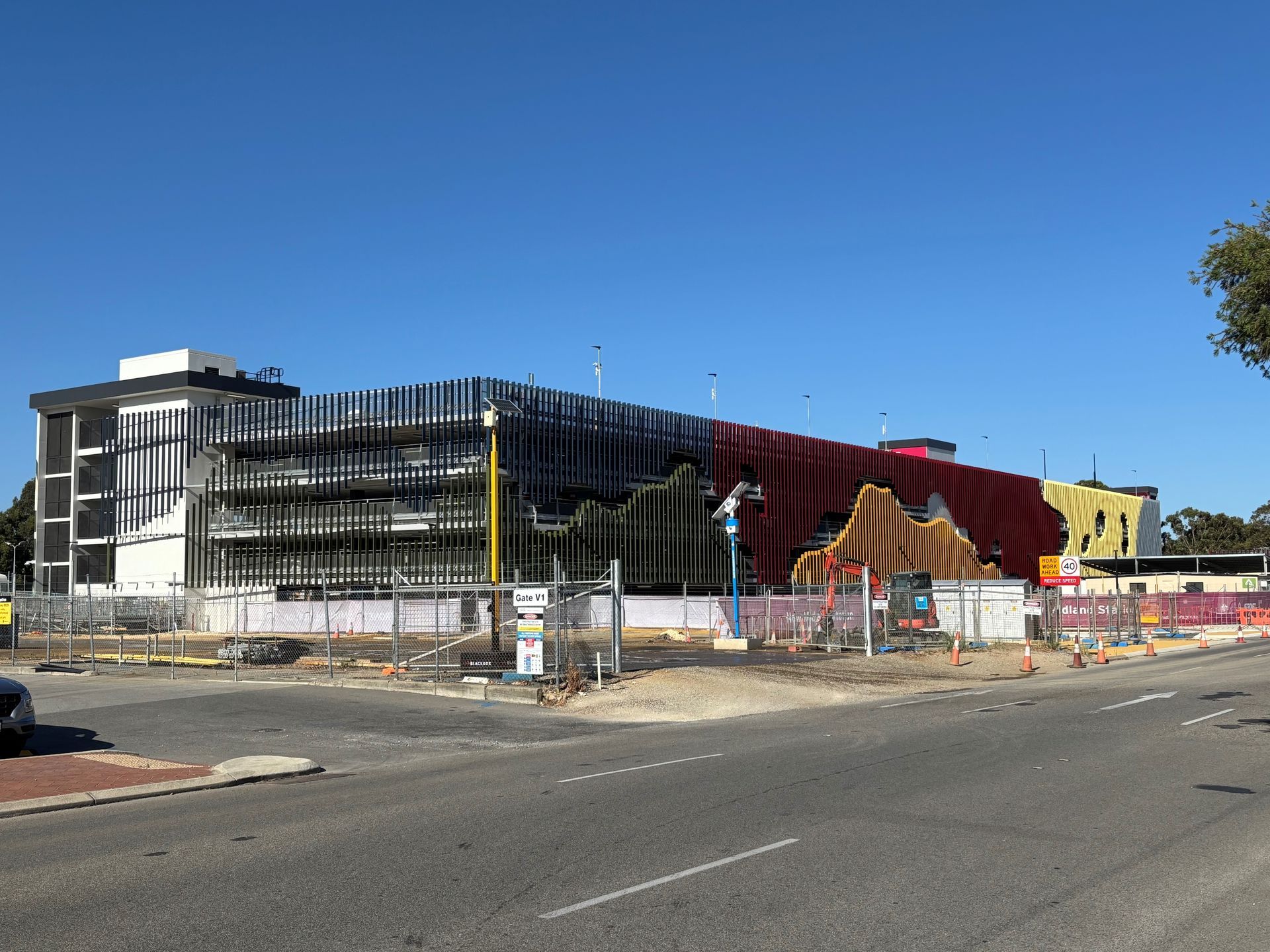 A group of people are walking in front of a tall building.