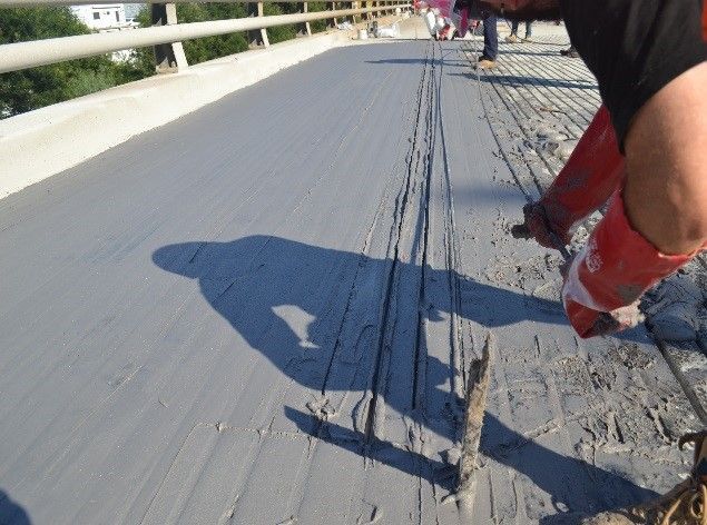 A person is working on a bridge and their shadow is on the ground