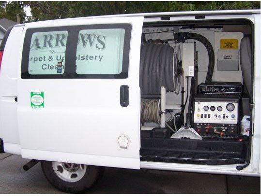 White van with open side door; inside, cleaning equipment and hose, branded 