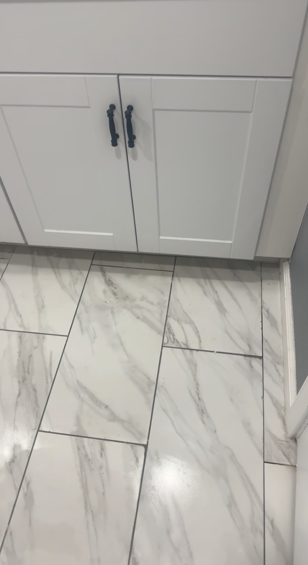 Room under construction, white walls and windows, building materials scattered on floor.