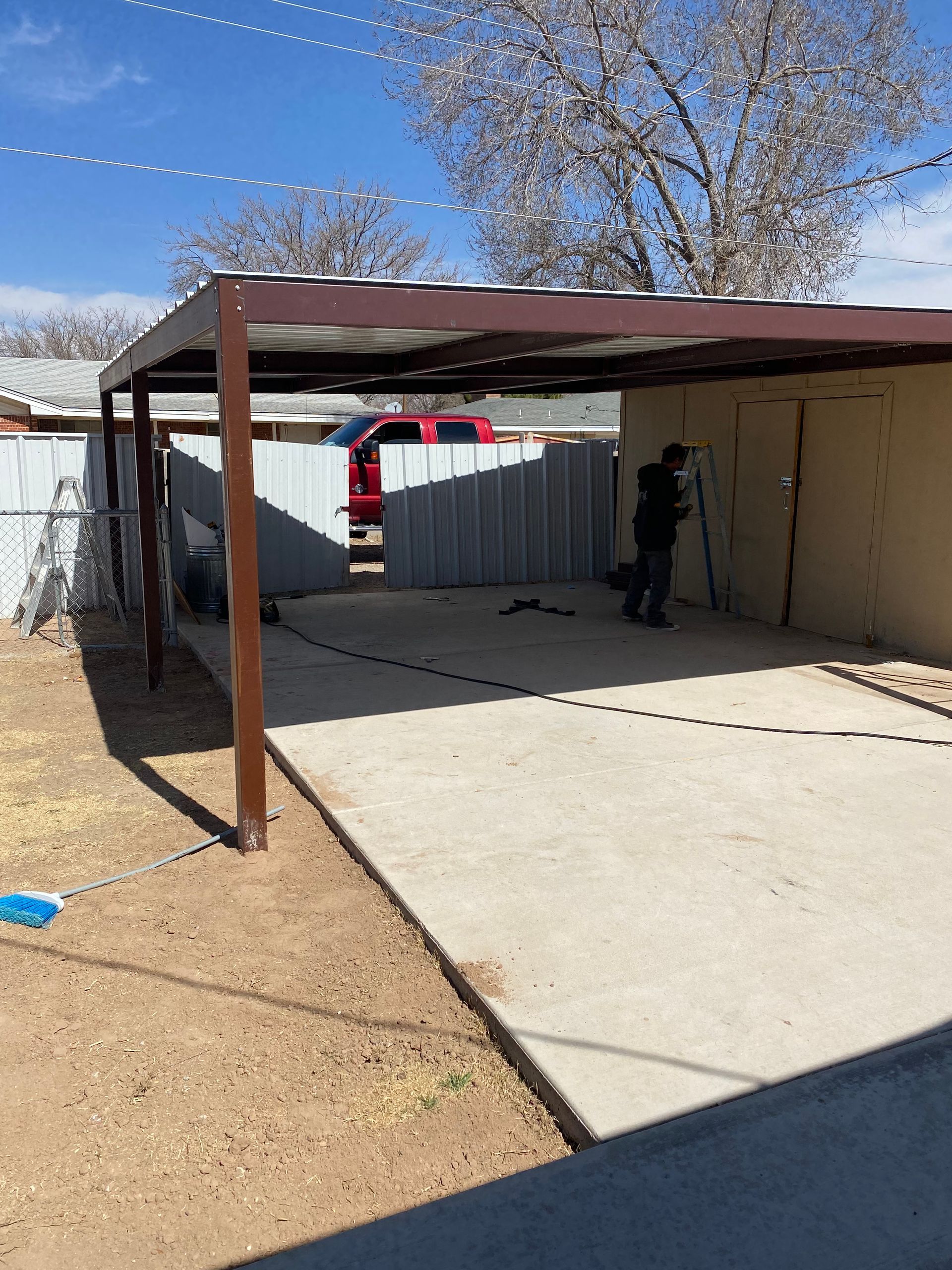 Red car parked in front of a white garage door; house exterior visible.