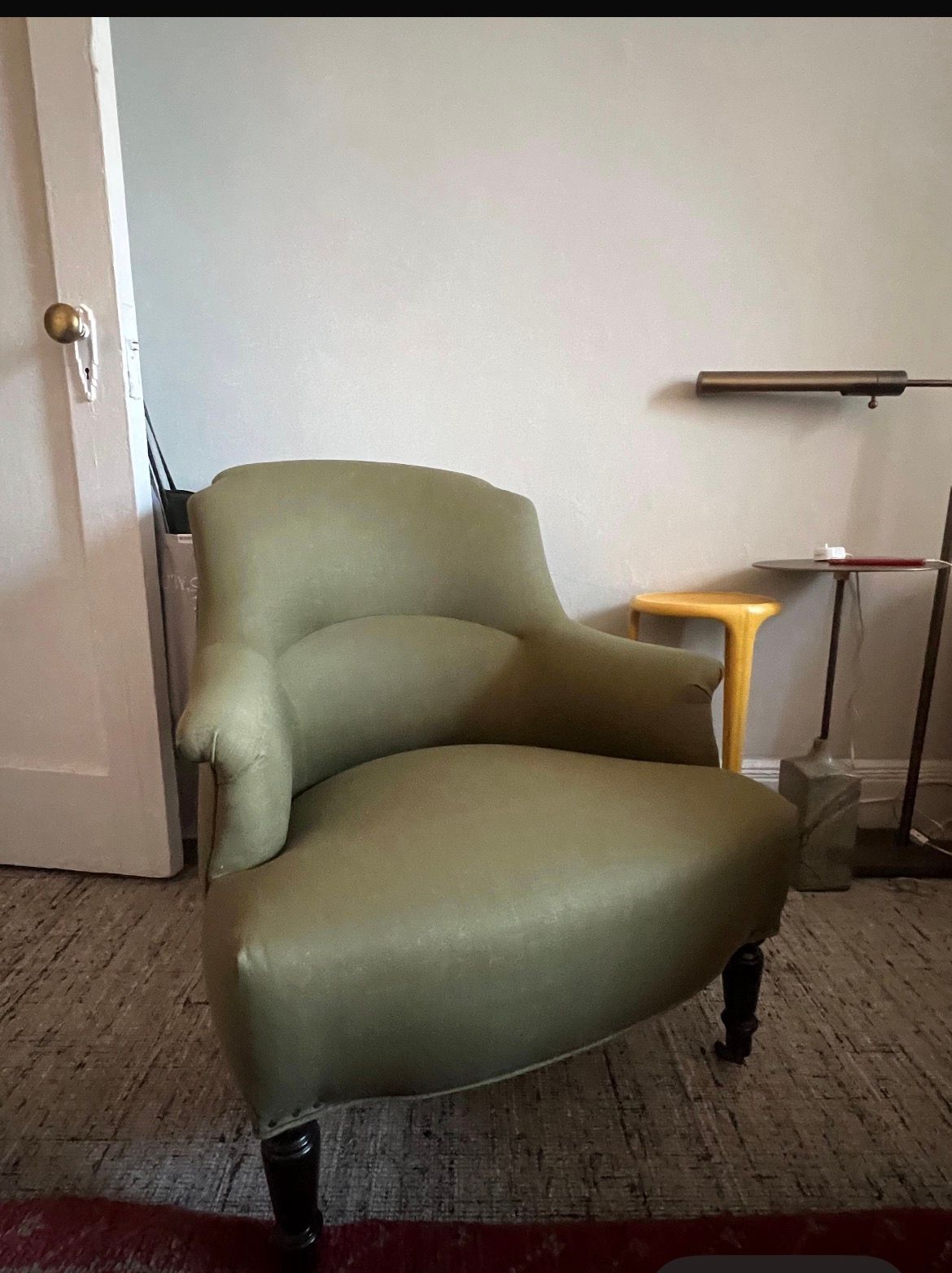 Green upholstered armchair in a room.