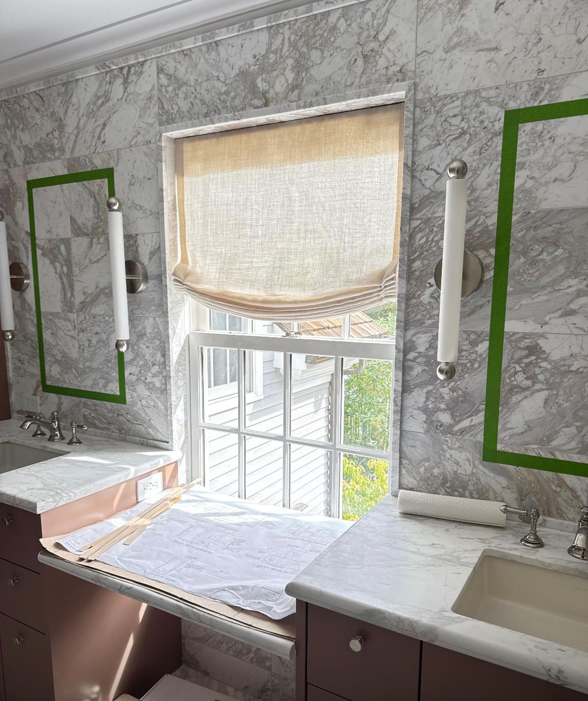 Cozy kitchen with gray and white cabinets, a light wooden countertop, and fresh flowers in a vase.