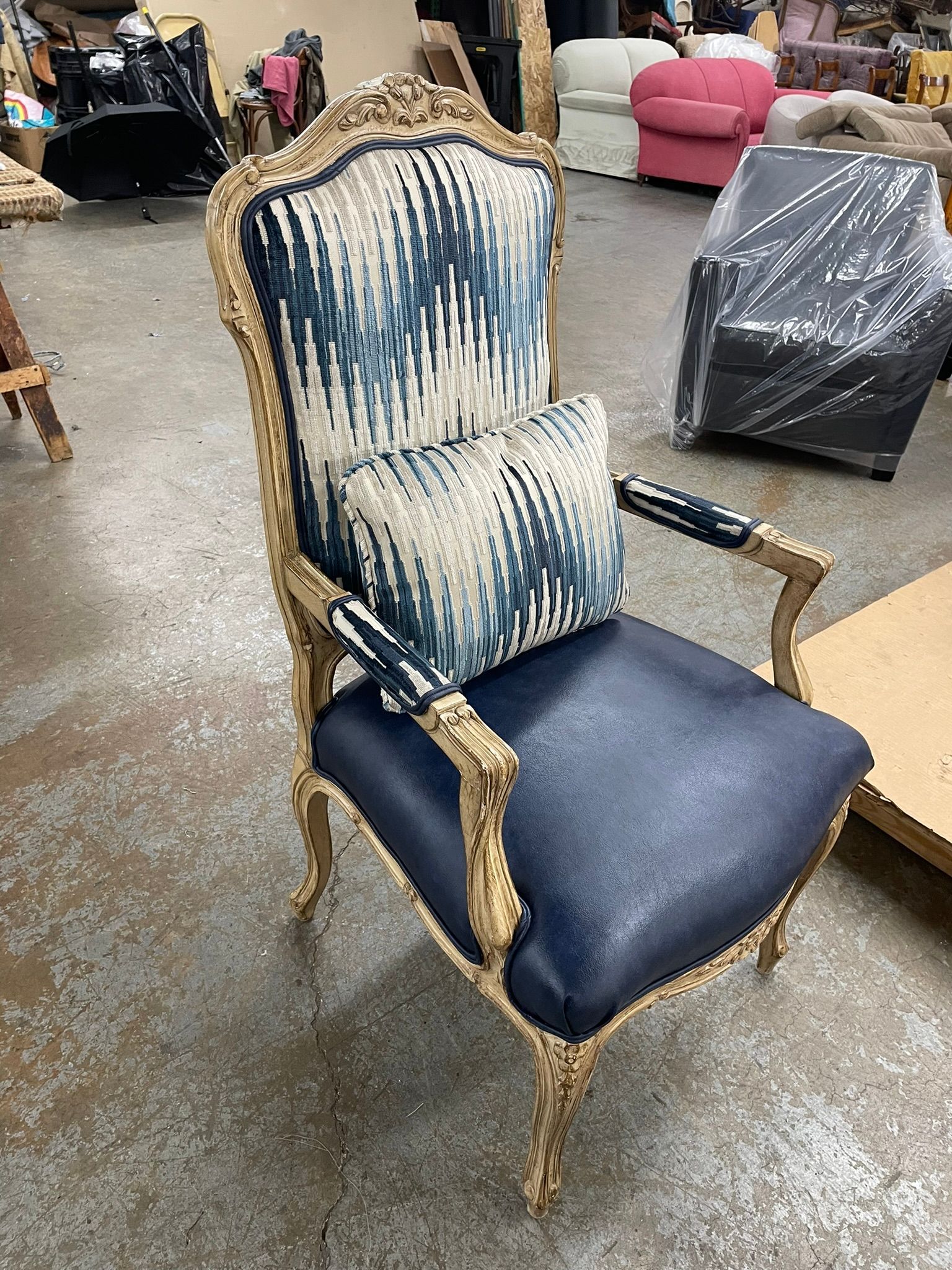 Ornate gold-framed armchair with blue and white patterned fabric back and pillow, blue seat.