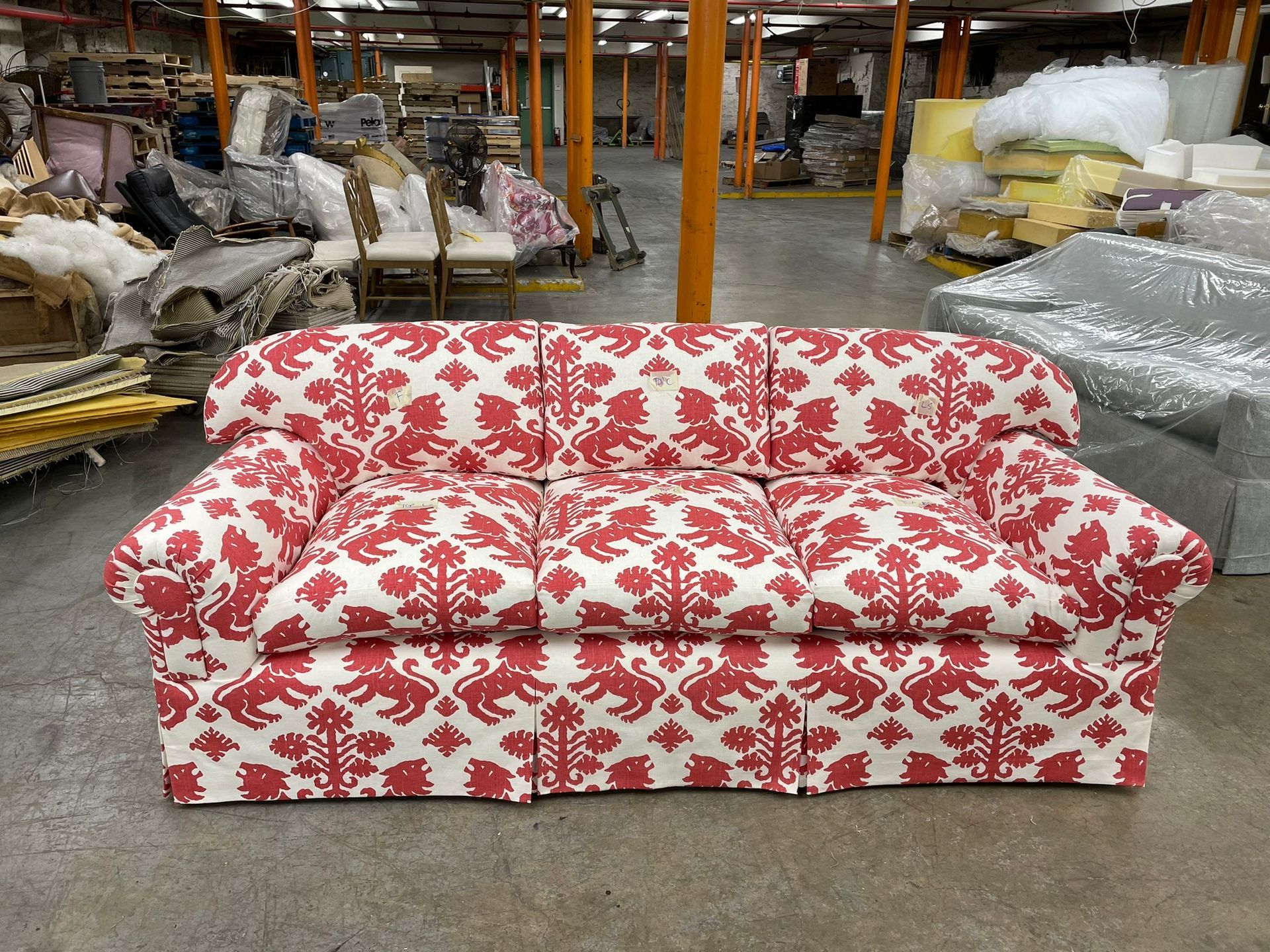 Red and white patterned sofa in a warehouse.
