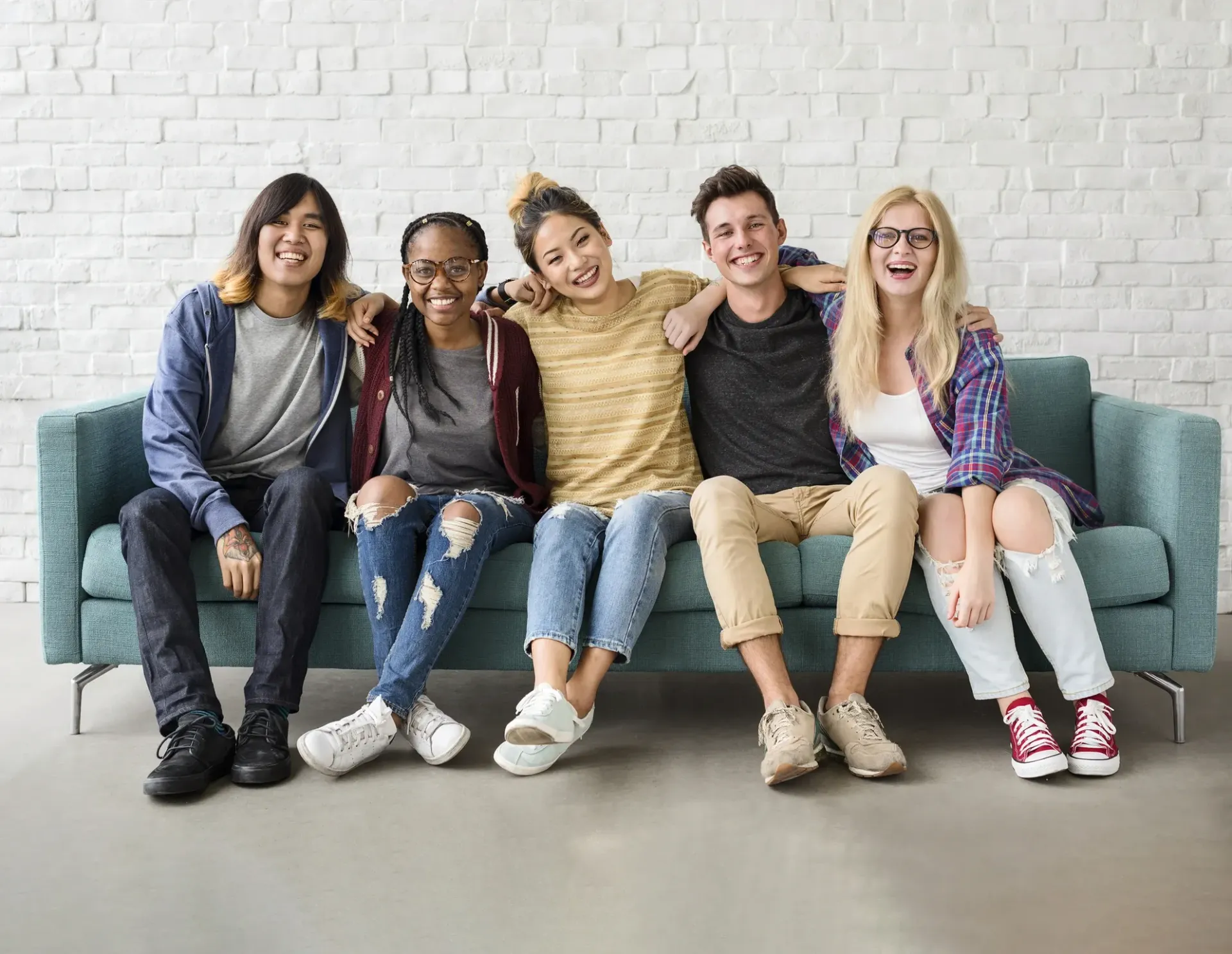 A group of young people are sitting on a couch.