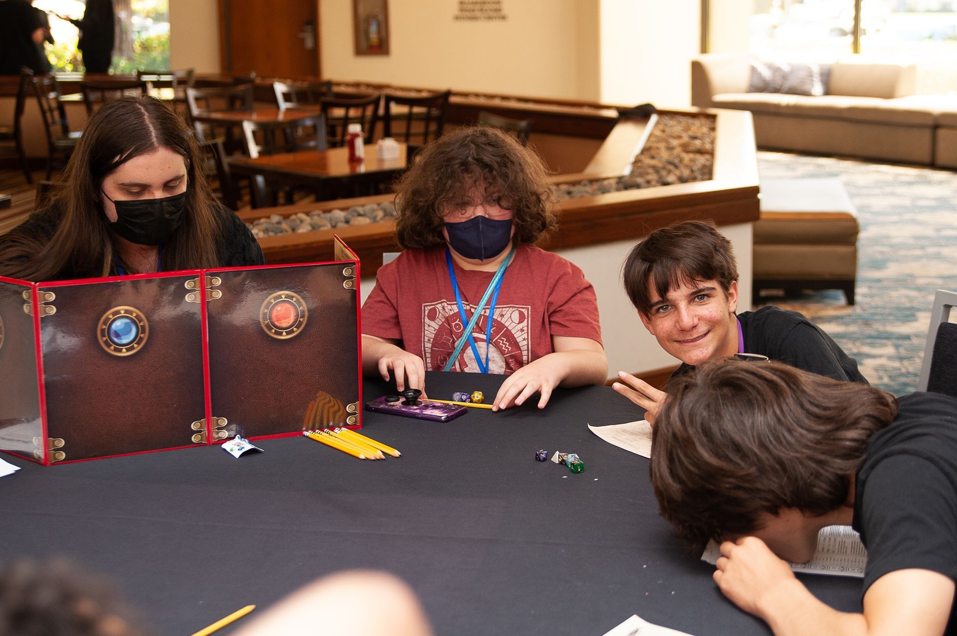 A group of young people are sitting around a table playing a game.