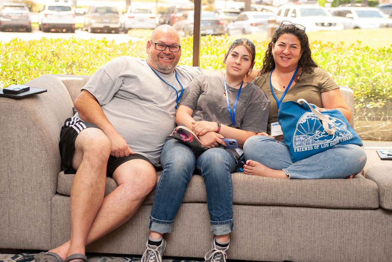 A man and two women are sitting on a couch.