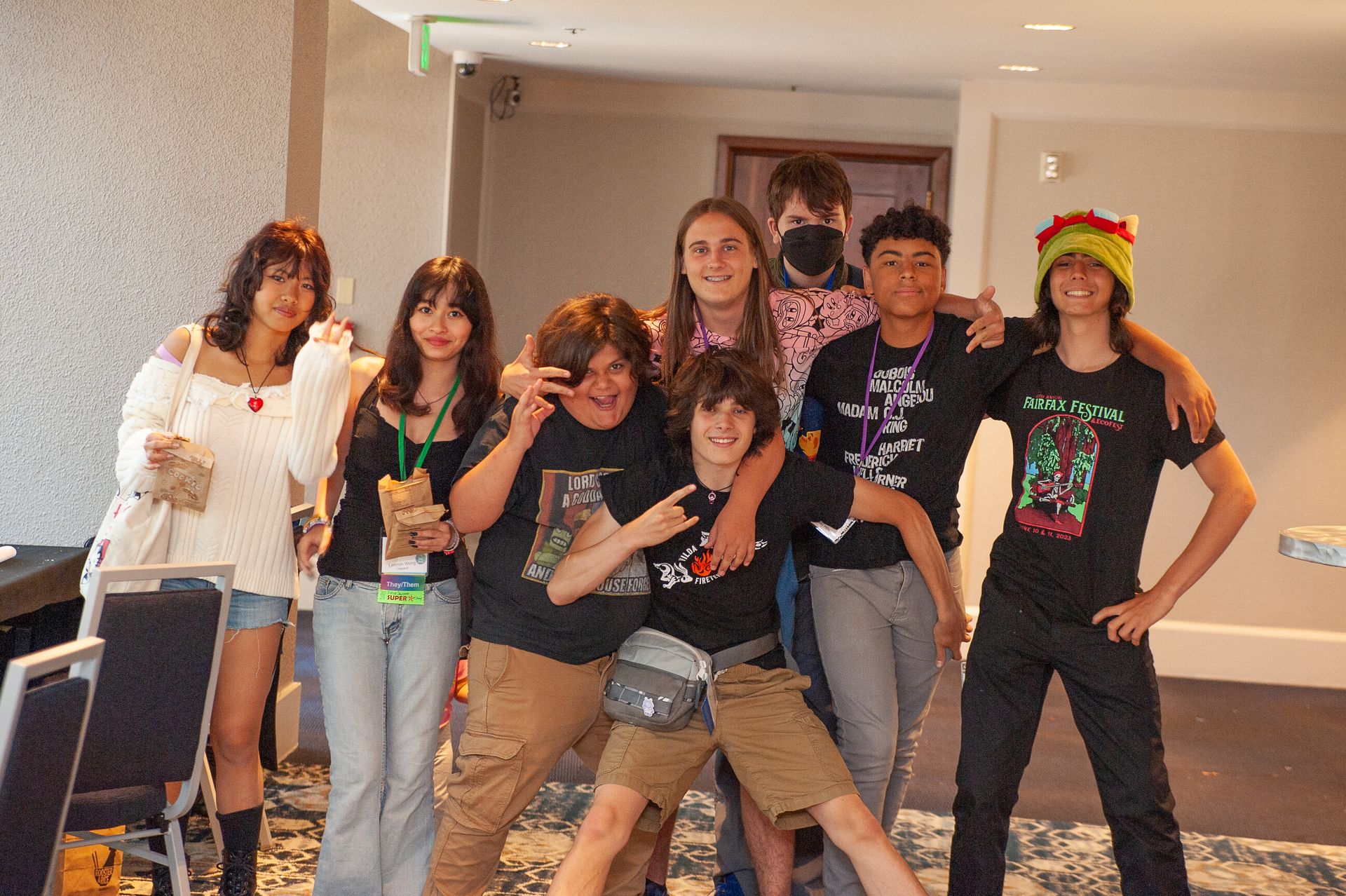 A group of young people posing for a picture in a room.