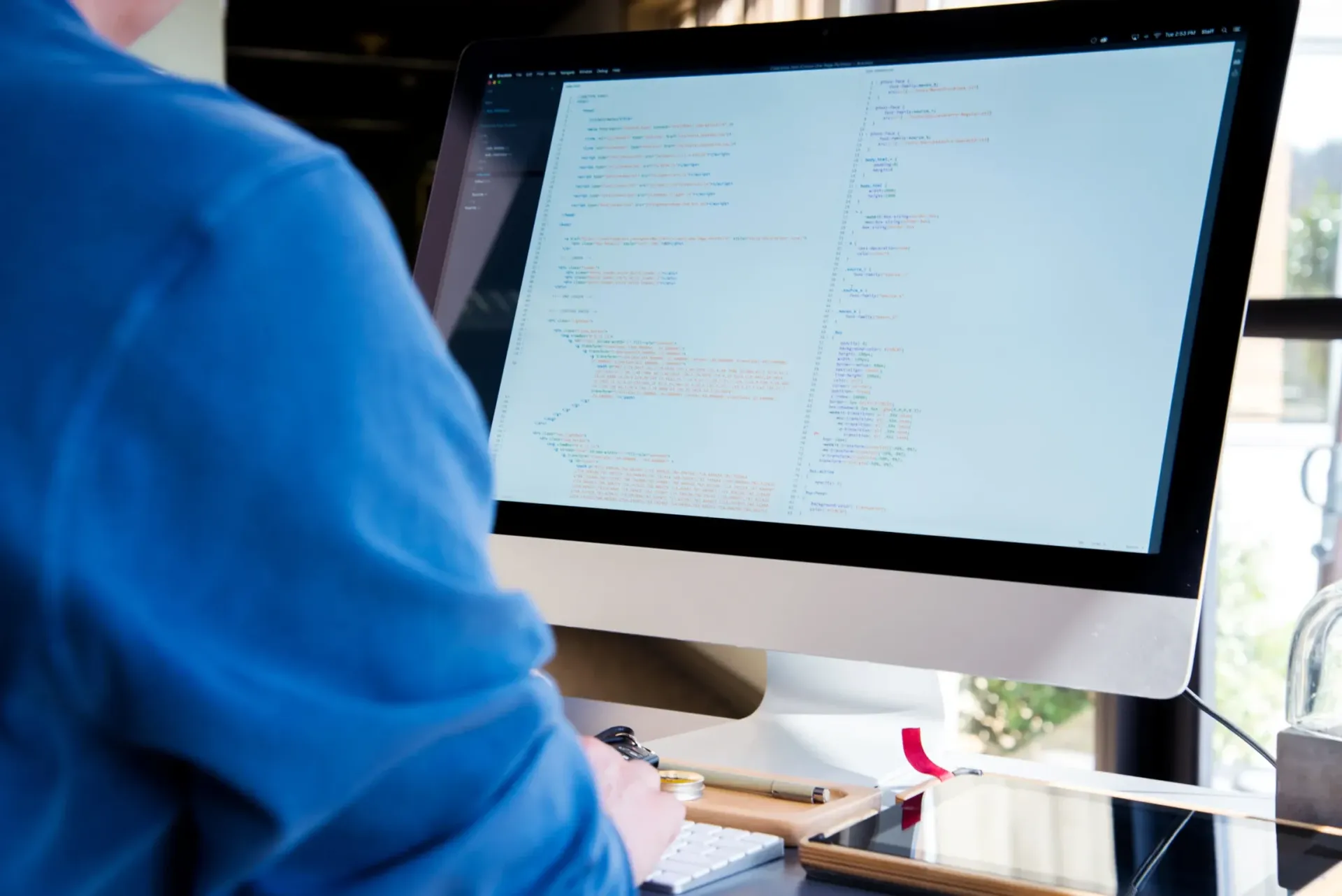 A man in a blue shirt is working on a computer