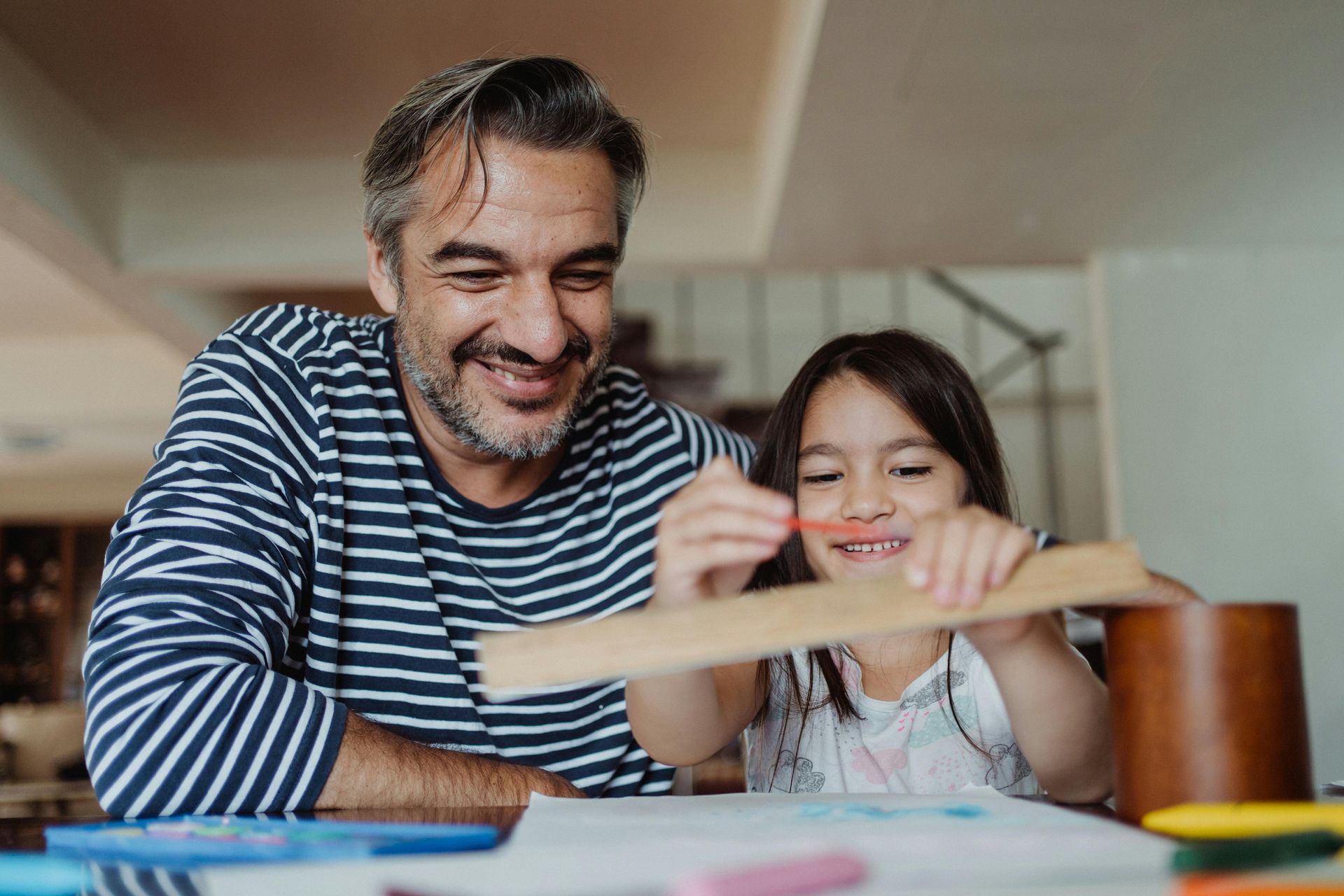Father homeschooling his daughter at home in California.