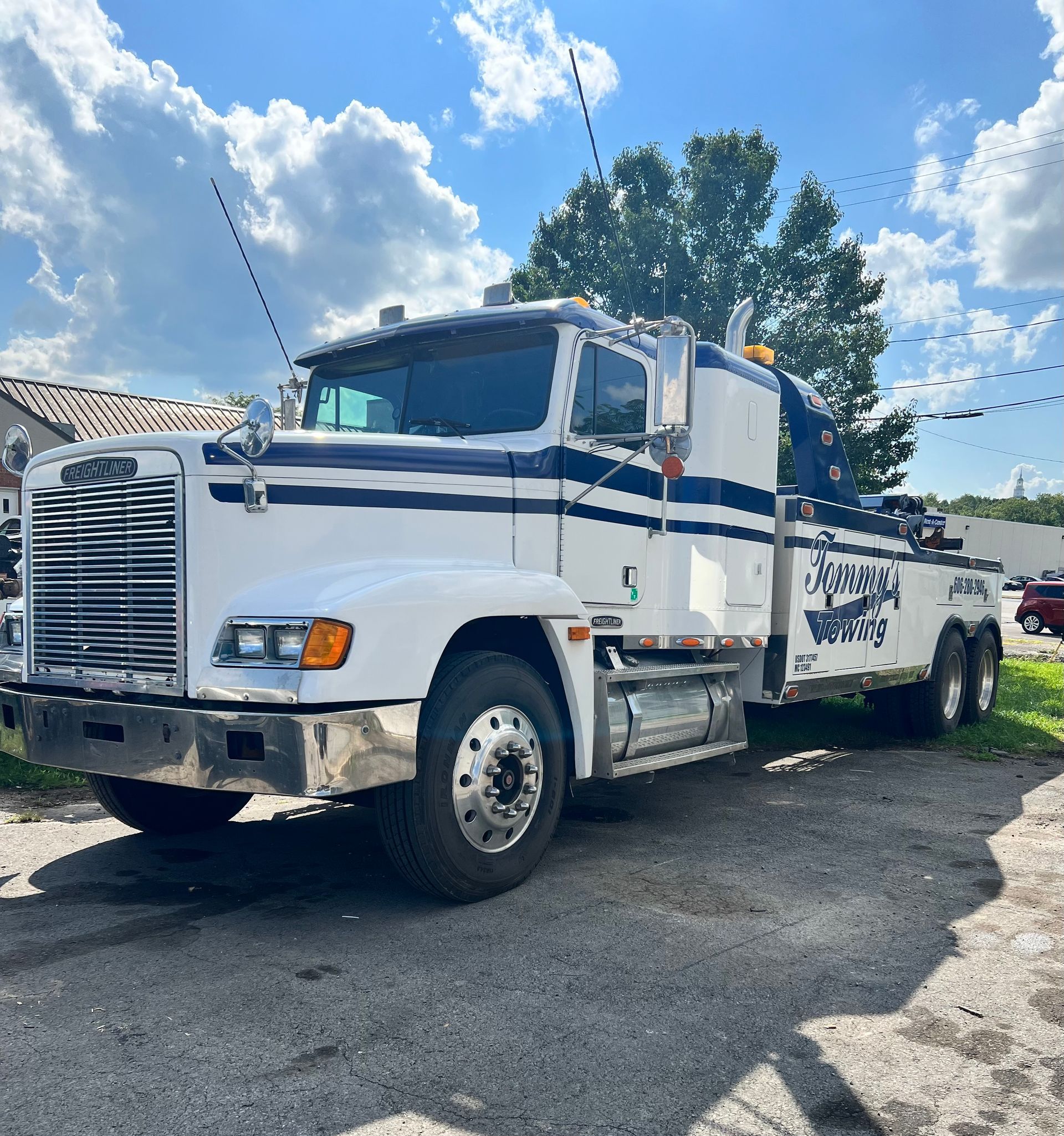 A white tow truck is parked on the side of the road.