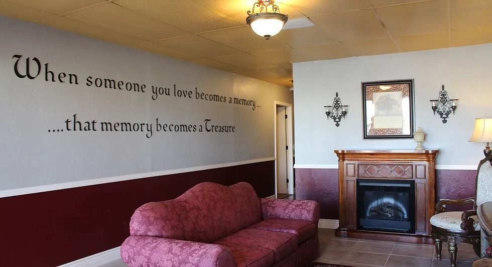 Living room with red sofa, fireplace, and wall quote: 