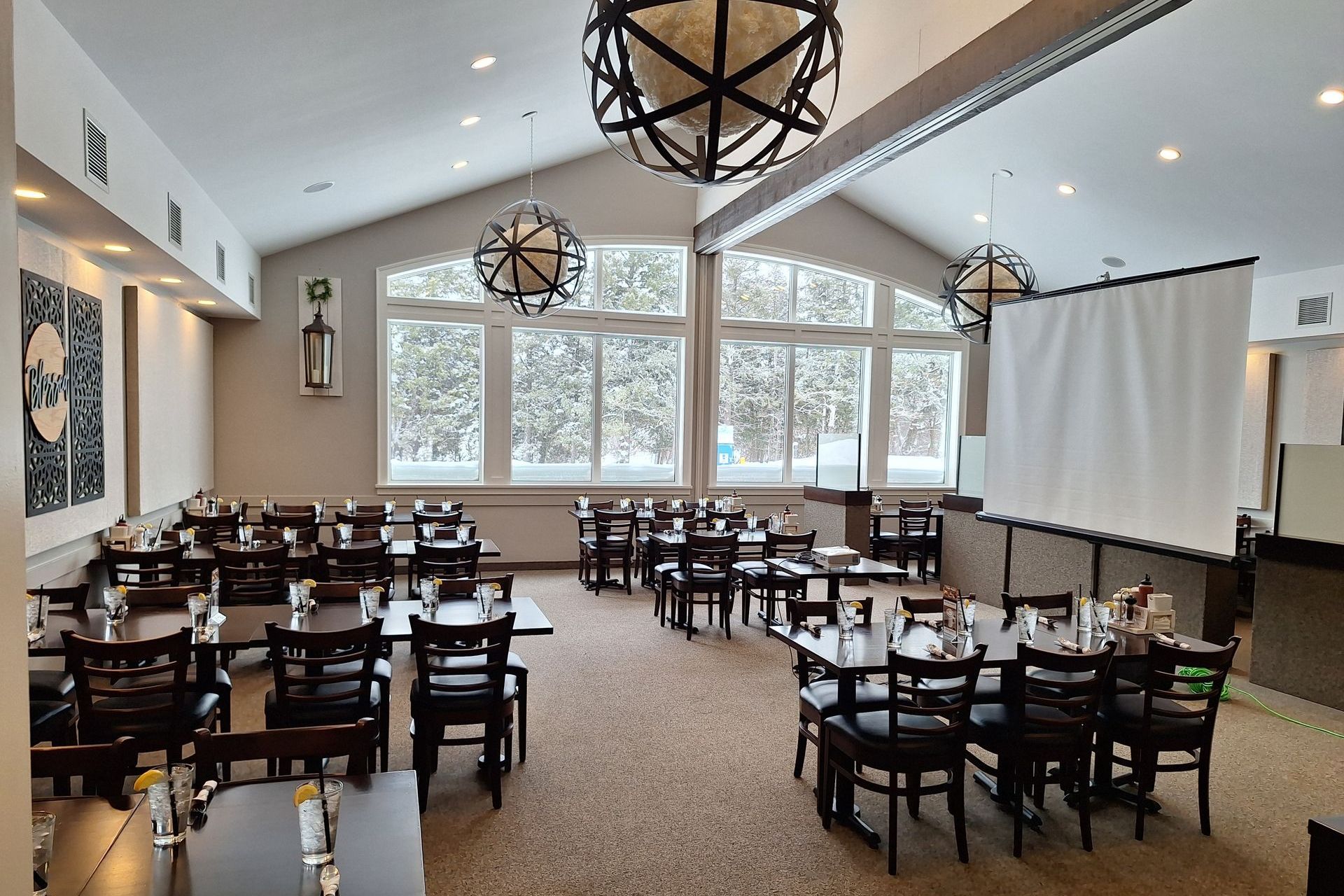 A large dining room with tables and chairs and a vaulted ceiling.