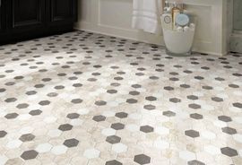 Bathroom floor tiled with a repeating geometric pattern of white, beige, and dark gray hexagonal tiles.