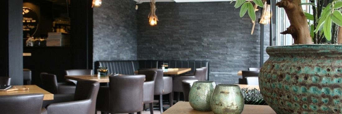 Een close-up van twee sandwiches met gerookte zalm en eisalade op gesneden volkorenbrood met verse rucola.