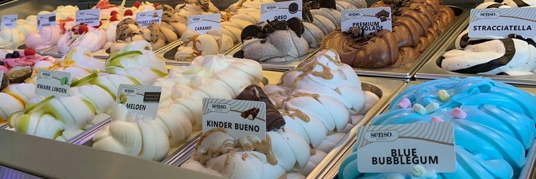 Een close-up van twee sandwiches met gerookte zalm en eisalade op gesneden volkorenbrood met verse rucola.