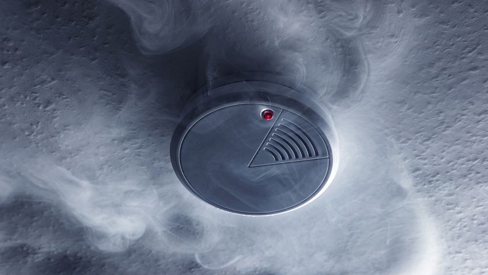 A Smoke Detector is Surrounded by Smoke Coming Out of It — Mick Sawtell Electrical Pty Ltd in Coolangatta, QLD