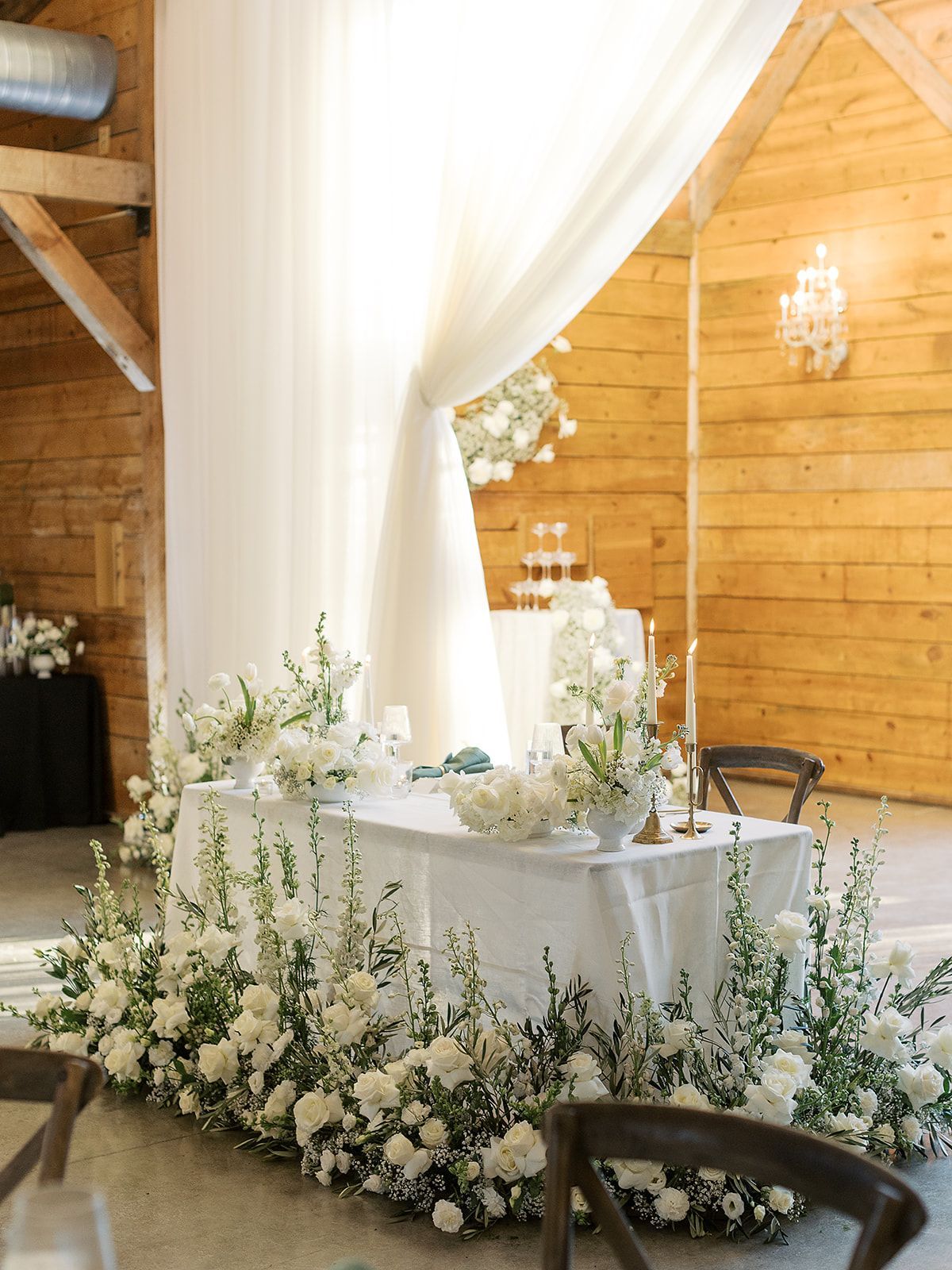 A table decorated with white flowers and candles in a room.