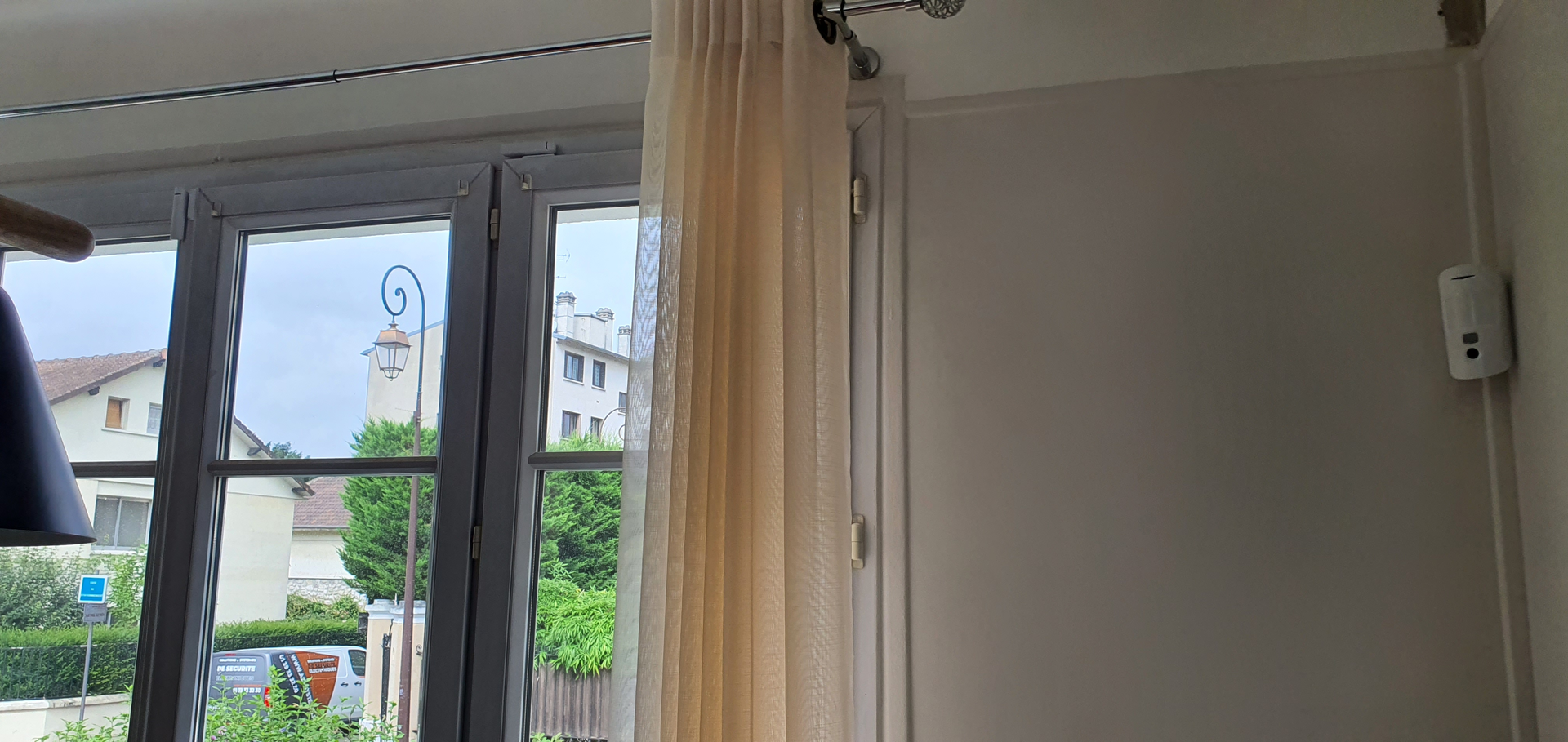 Un salon avec une grande fenêtre et une lampe.